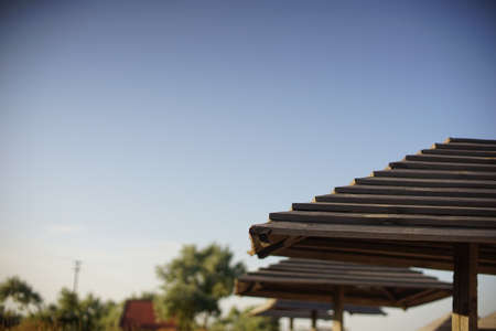 Wooden beach umbrellas on a blue sky backgroundの写真素材