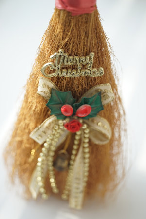 Toy broom with decor and golden text Merry Christmas on white tableの写真素材