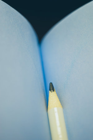 White pencil in a blue notebook on clean paper.