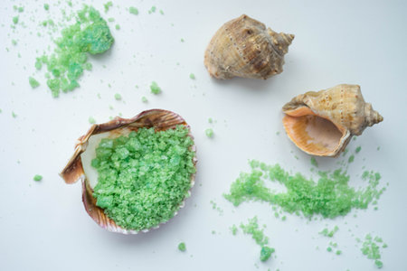 green sea salt in a seashell on a white tableの写真素材