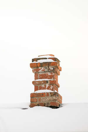 Old red brick chimney with white snow and sky.の写真素材