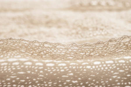 Closeup pale beige lace unwound on a white table.の写真素材