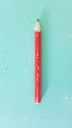 Red construction pencil on dirty green drywallの写真素材