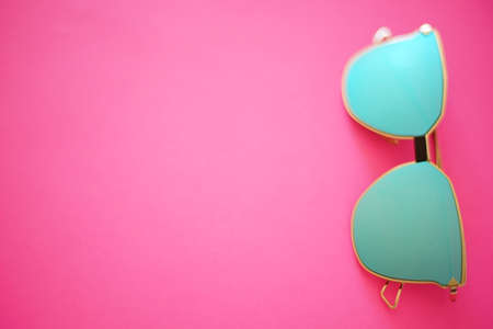 Blurred blue sunglasses on a vivid pink background. Copy spaceの写真素材