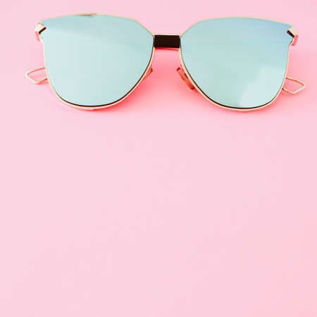 Pale blue sunglasses on a pastel pink backgroundの写真素材