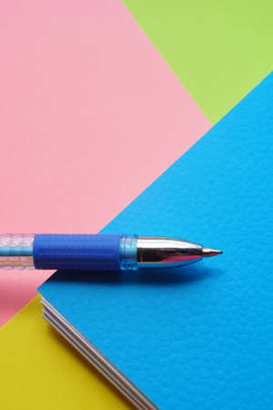 Blue ballpoint pen on different paper colors.
