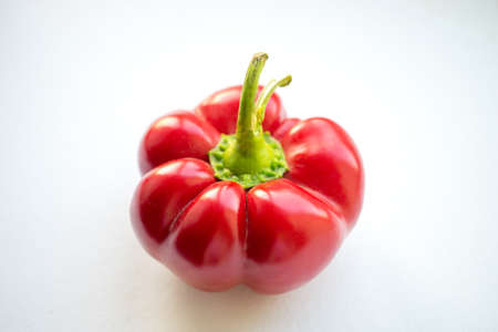 Thick ripe red peppers on a white table.の写真素材