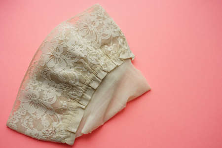 New beige stockings with elastic lace on the pink table. Top viewの写真素材