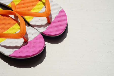 Colored beach flip flops on a striped towel. Positive summer still life. View from above. Copy spaceの写真素材