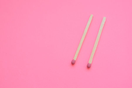 two matches on a pink paper table.の写真素材