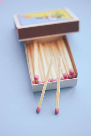 Matches in an open box on a pastel blue table.
