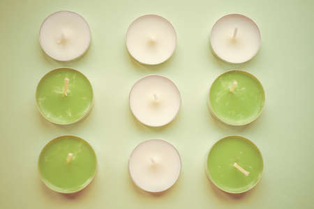 Set of new lime and white candles on pale green table. Top view.の写真素材