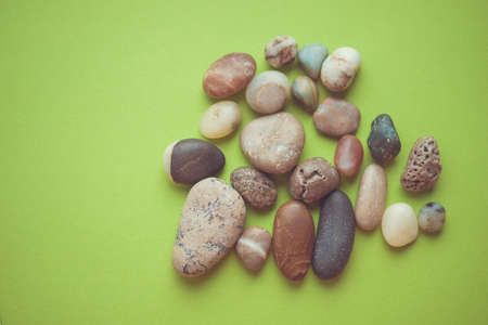 Heap of clean pebble stones on green table.