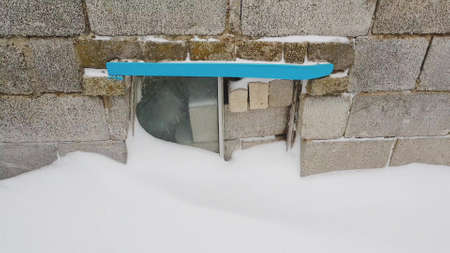 bricks and cinder blocks from the bus window on the front wall with snow