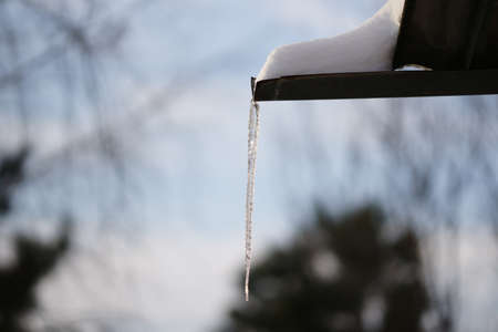 Huge long icicle hang in sunny blue sky background.