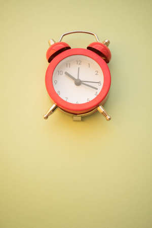 new red round clock on pale green table, copy spaceの写真素材