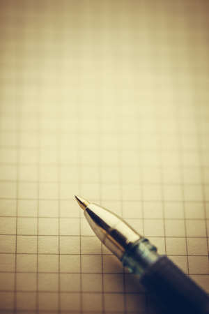 Ballpoint pen on a notepad in a cage with copy spaceの写真素材