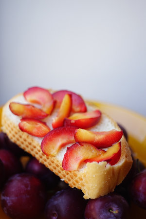 Sandwich with plum slices in a plate with plumsの写真素材