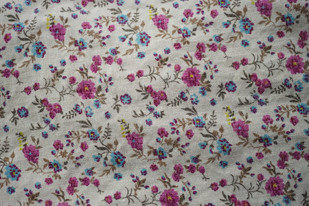 Cute linen fabric with a floral pattern, pink and blue flowers on a beige material.