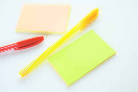 Yellow and red ballpoint pen and notes on white paper.