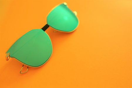 Green sunglasses on a orange background. copy spaceの写真素材