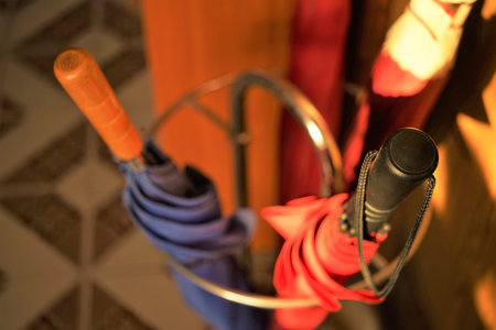Set of three closed umbrellas in a metal stand