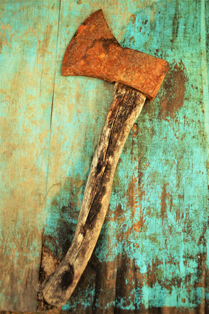 Old rusty ax lies on the blue shabby tableの写真素材