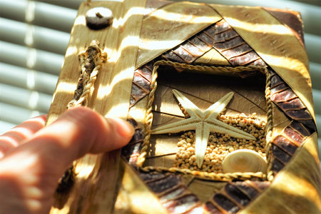 Hand hold natural eco notebook made of leaves, sand and seashells.の写真素材