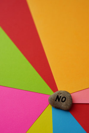 Pebble stone with text no on them. Colorful background from sheets of paper.の写真素材