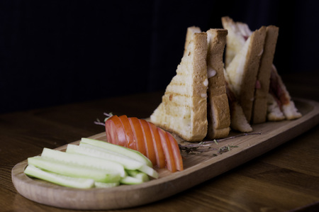 sliced cheddar and sausage toast cucumber tomato tea prepared for breakfastの写真素材