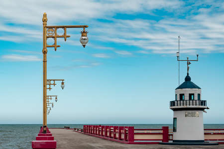 View of the embankment with lanterns and watchtower in front of the seaの写真素材