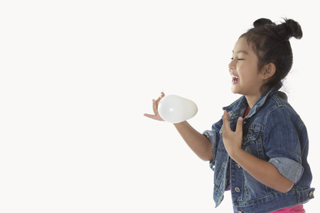 Child Denim shirt tied malformation playing with balloons.の写真素材