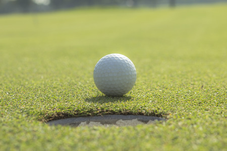 Tam Golf balls on the lawn green. Golf ball in the hole.の写真素材