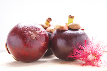 Mangosteen fruit and cross section showing the thick purple skin and white flesh of the queen of fruits.の写真素材