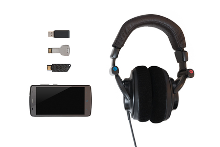 Multiple flash memories with a cellphone and headphones on isolated whiteの写真素材