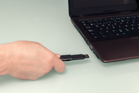 USB flash memory on hand with notebook computer