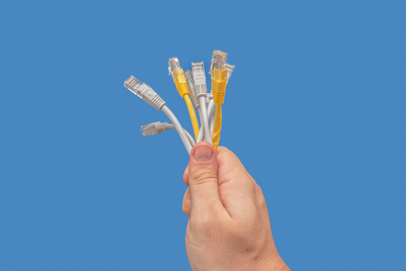 Several network cables in the hand. On blue backgroundの写真素材
