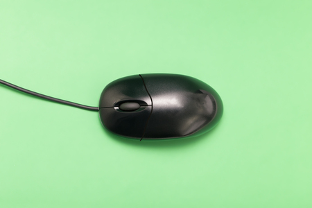 Black USB mouse with cable. On green backgroundの写真素材
