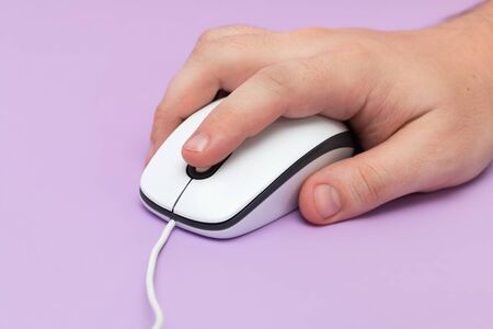 USB mouse with cable in hand. On purple background