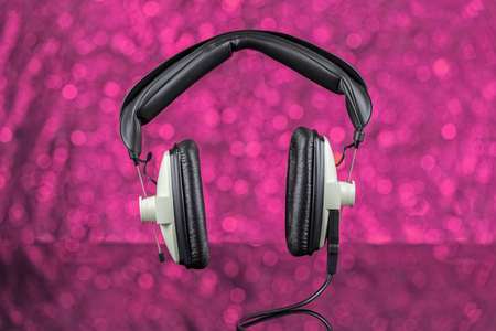 Old headphones. On pink background out of focusの写真素材