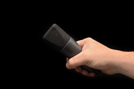 Microphone close up in hand, mic.  On black backgroundの写真素材