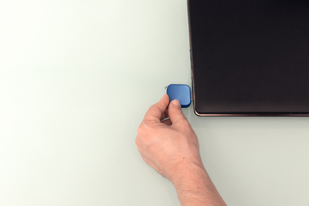 USB blue flash drive on hand with notebook computer. Top view