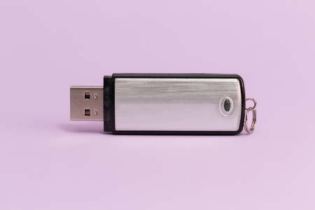 Metal USB flash memory on a violet background. Front viewの写真素材