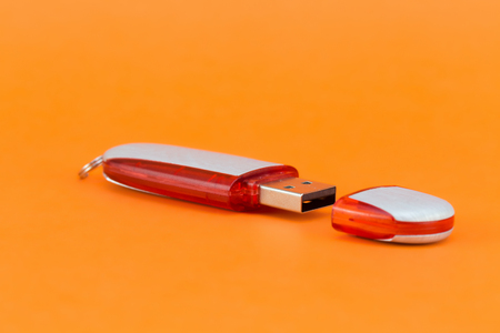 Red USB flash memory on a orange background. Front viewの写真素材