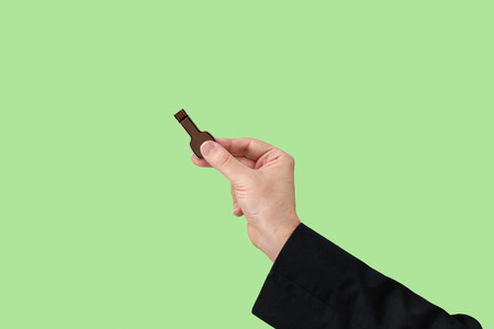 Key pen drive on hand with isolated green background. Front view