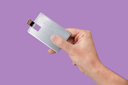 Card USB Flash drive on hand with isolated violet background. Front viewの写真素材