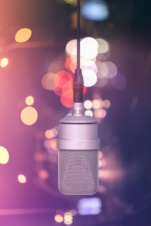 Professional microphone hanging on the cable, mic. Background defocused colors. Front viewの写真素材