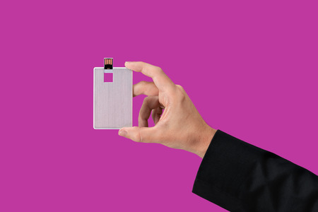 Card USB Flash drive on hand with isolated pink background. Front viewの写真素材