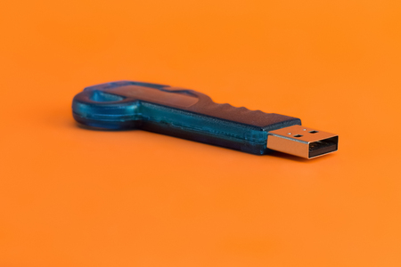 Blue USB flash memory on a orange background. Pen drive