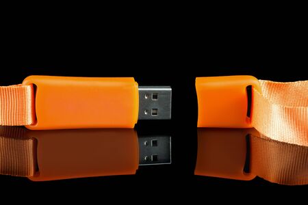 Memory stick USB orange with reflection on the surface. Black backgroundの写真素材